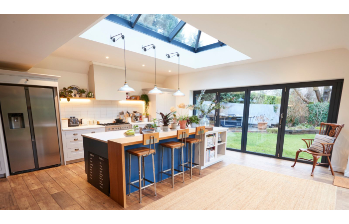large open kitchen with island, large roof lantern above, large bifold doors opening to garden