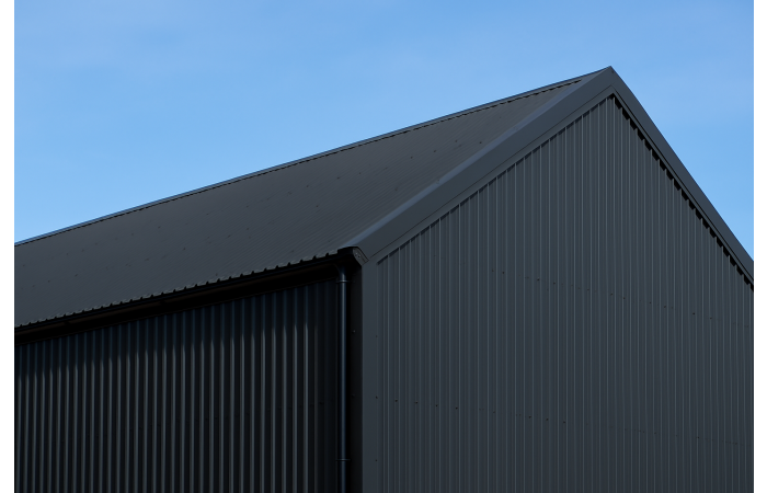 agricultural building clad and roofed with black metal roof sheets
