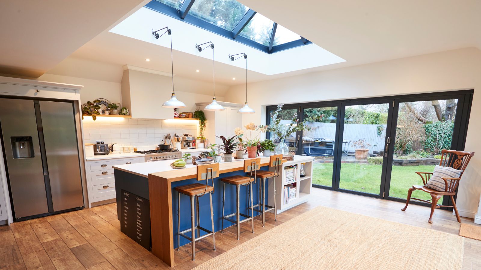 large open kitchen with island, large roof lantern above, large bifold doors opening to garden