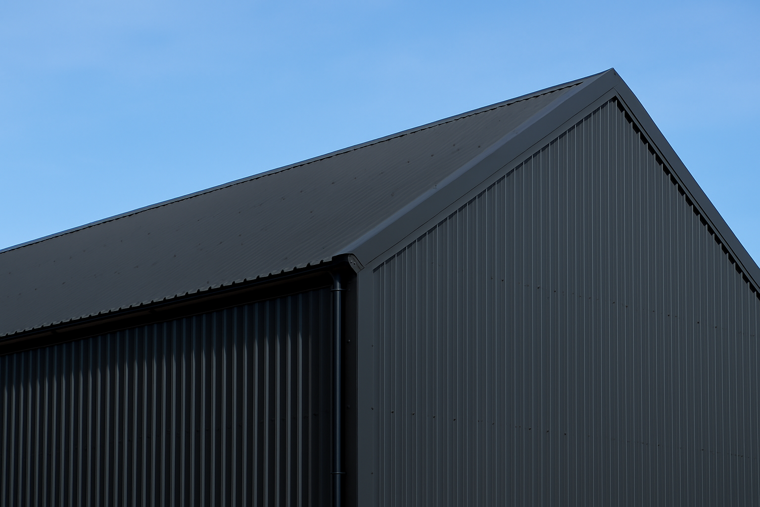 agricultural building clad and roofed with black metal roof sheets