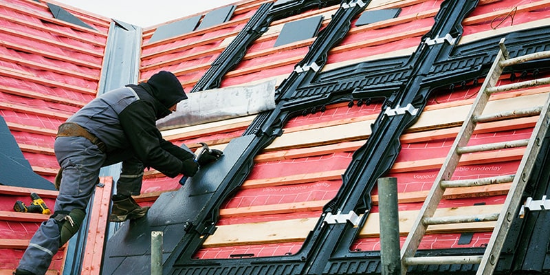 roofer replacing felt under tiles